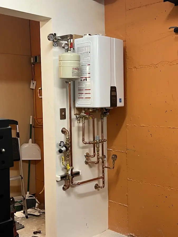 Plumbing technician inspecting water heater connections in Winona